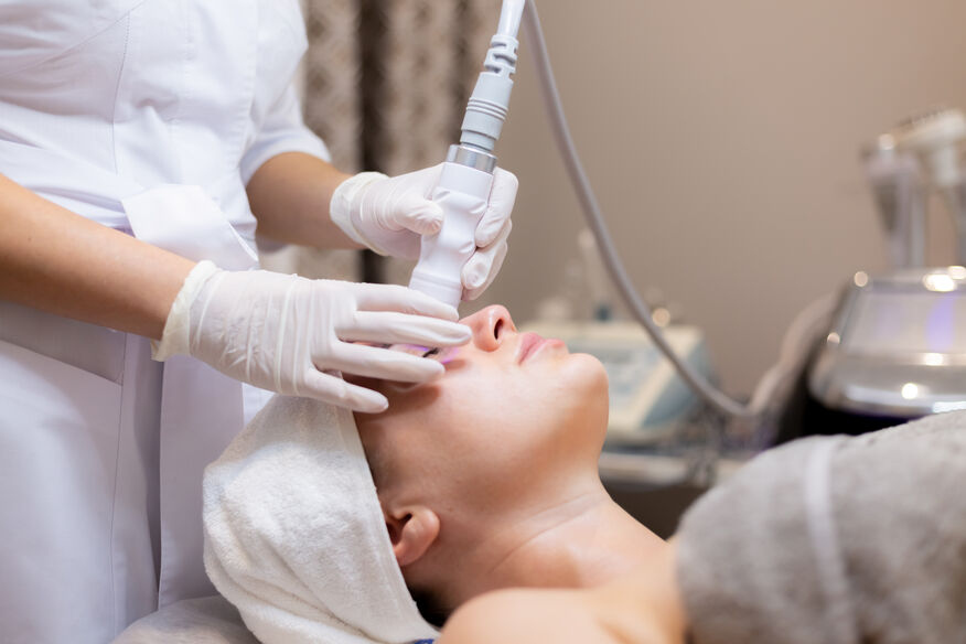 A woman receiving a facial treatment while relaxing in a serene spa environment.