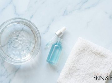 Minimalist skincare setup with water bowl, serum dropper, and towel — representing hydrodermabrasion facial Brisbane for deep cleansing and hydration.